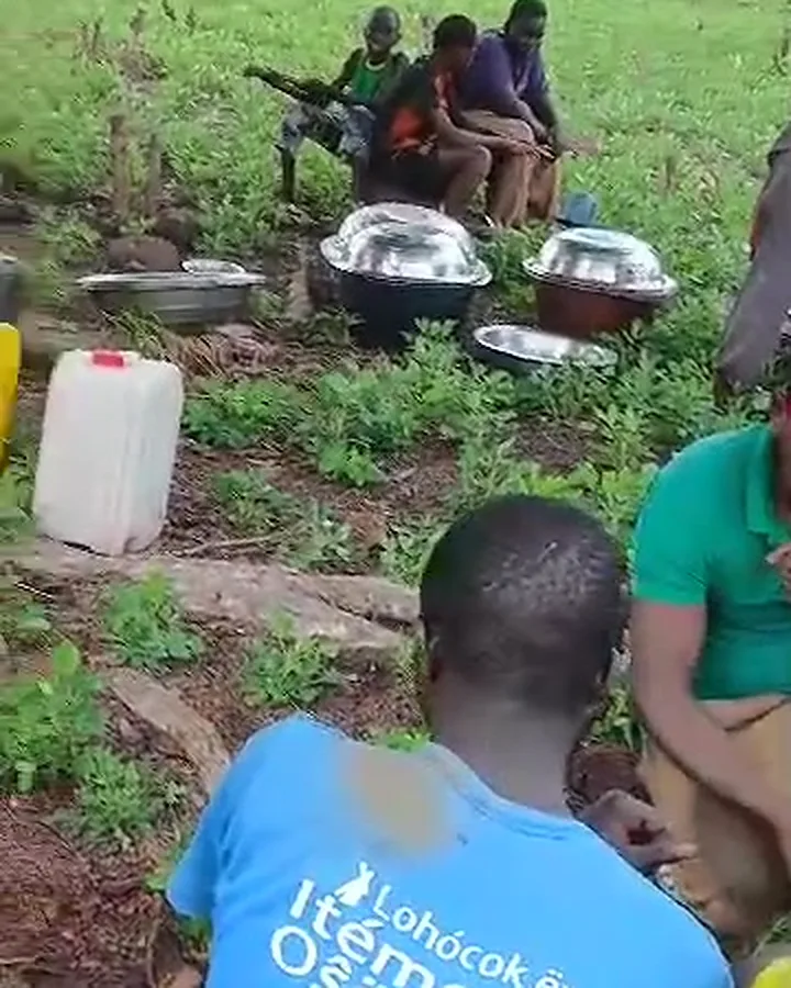 Workers sitting together in the field with pots of food and water cans